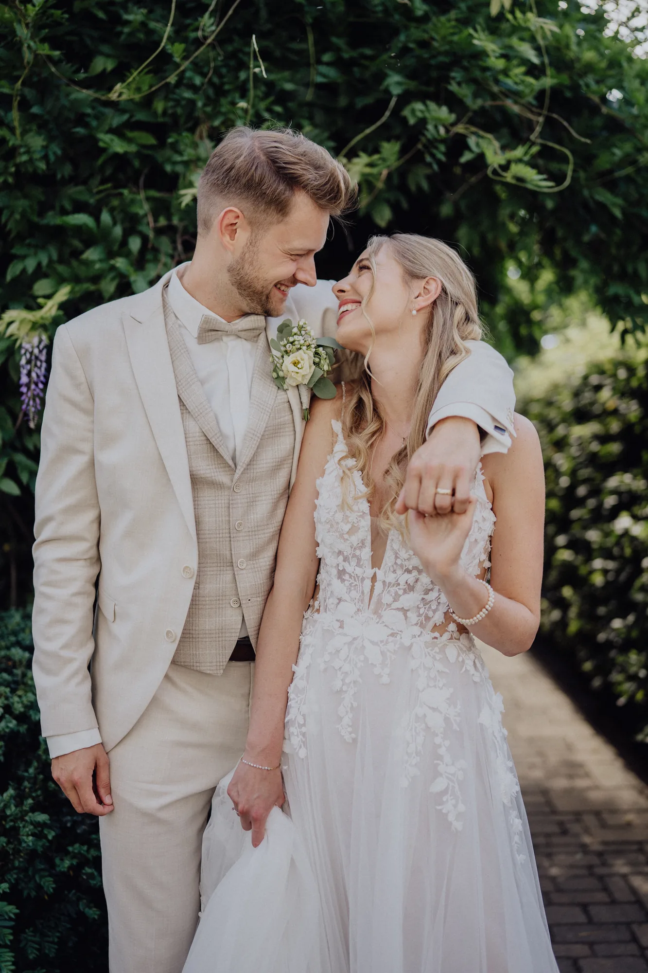 Joost legt den Arm um Anna, unter Blauregen im Garten – Hochzeit Anna & Joost, Romantik Hotel Fuchsbau, Timmendorfer Strand