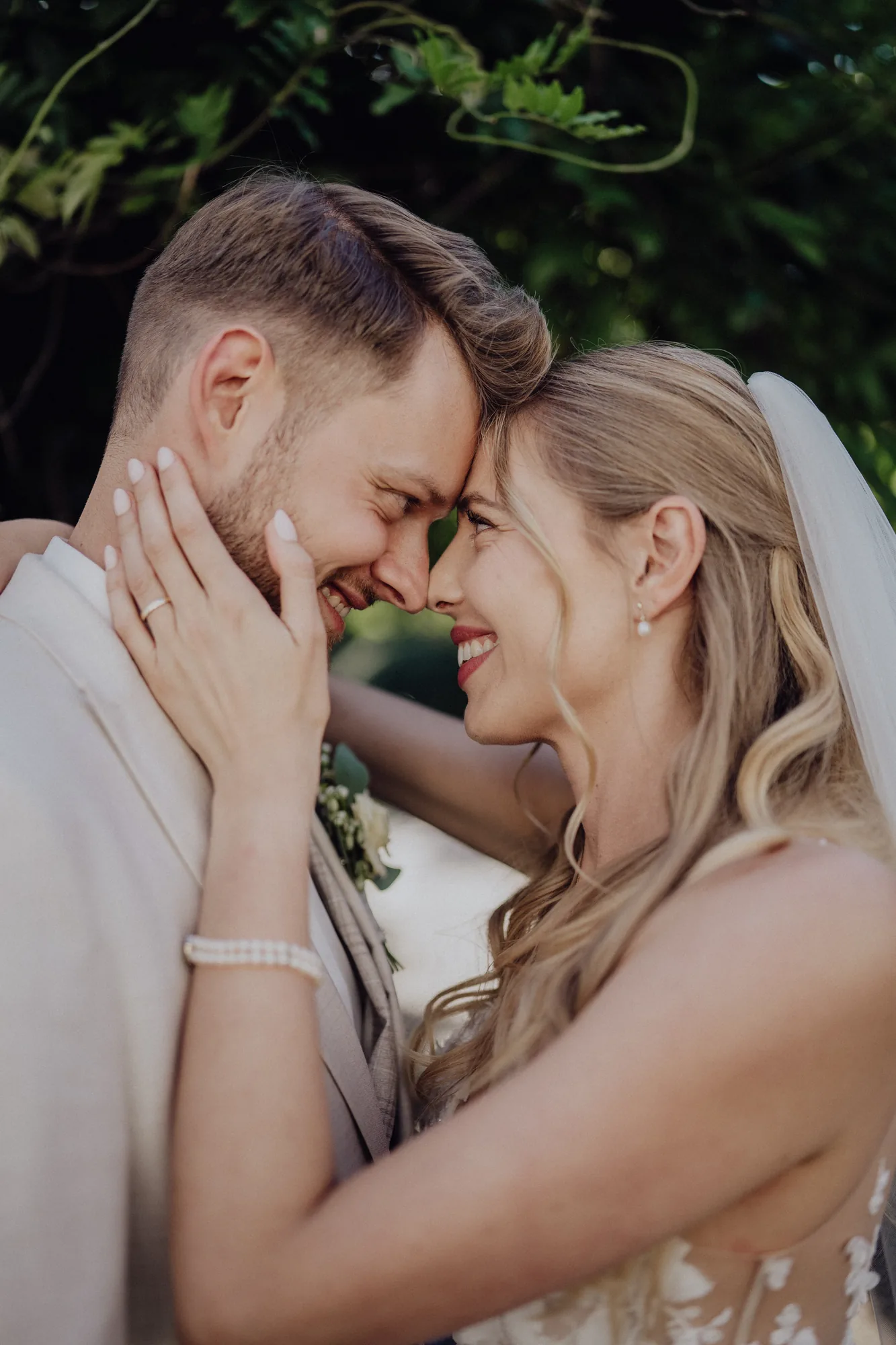 Anna hält Joosts Gesicht und lacht – Hochzeit Anna & Joost, Romantik Hotel Fuchsbau, Timmendorfer Strand