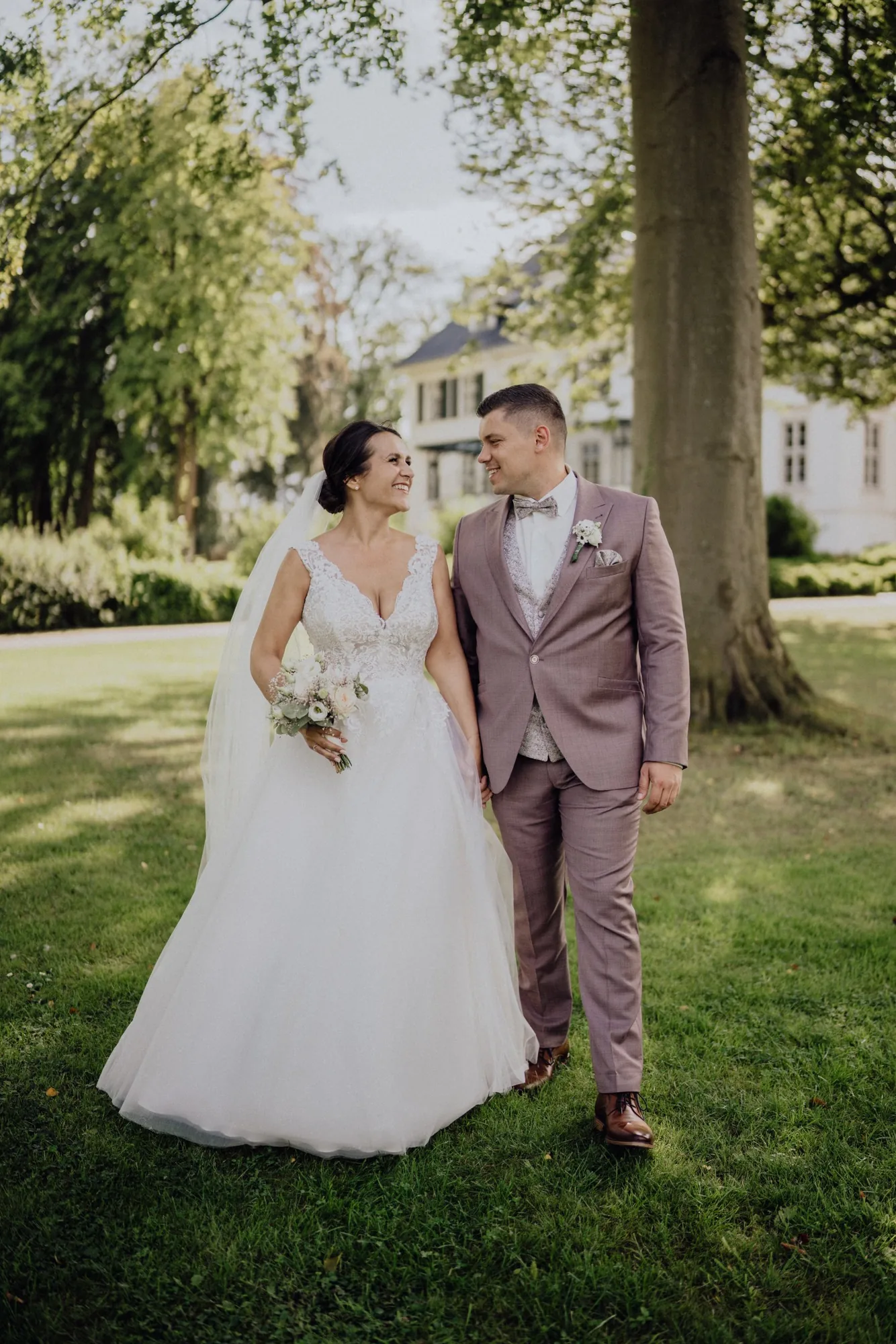 Bella und Tom gehen Hand in Hand durch den Park von Gut Immenhof – Hochzeit Bella & Tom, Gut Immenhof, Malente