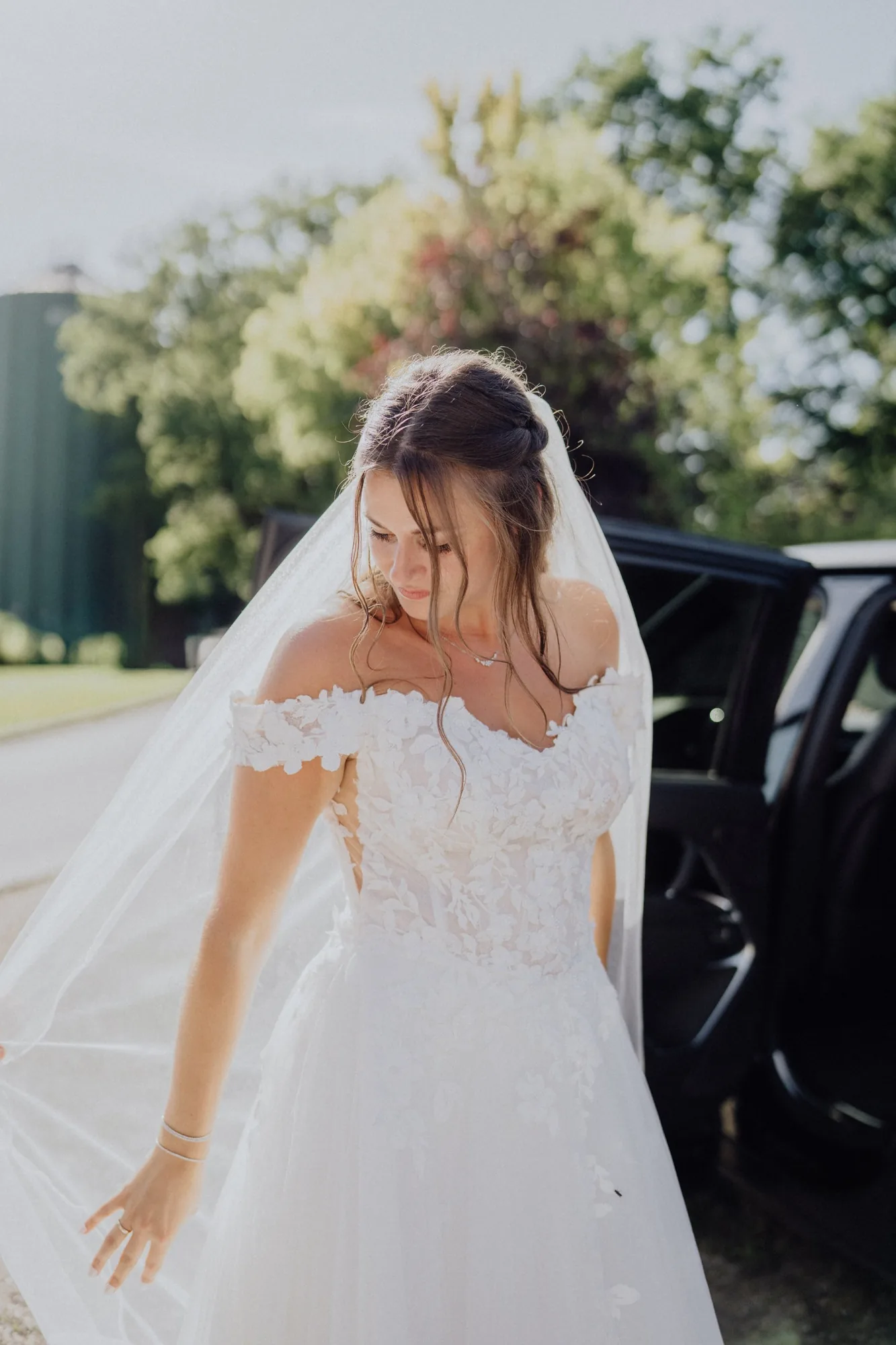 Franzi steigt im Brautkleid mit langem Schleier aus dem Auto – Hochzeit Franzi & Tim, De Ole Schüün, Hüttblek