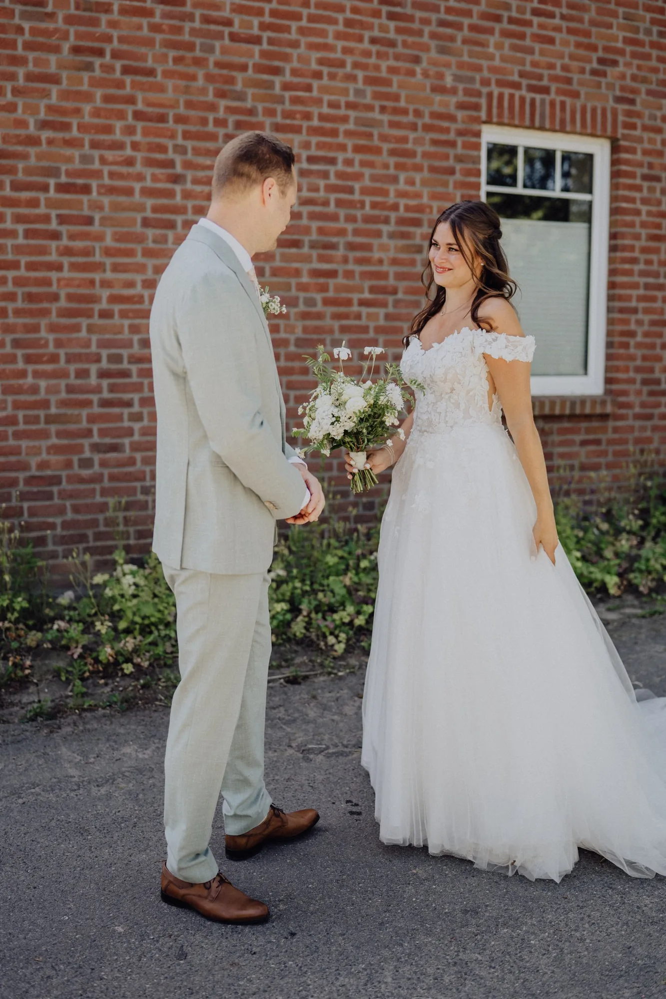 Franzi geht mit ihrem Brautstrauß auf Tim zu, der mit dem Rücken zu ihr wartet – Hochzeit Franzi & Tim, De Ole Schüün, Hüttblek