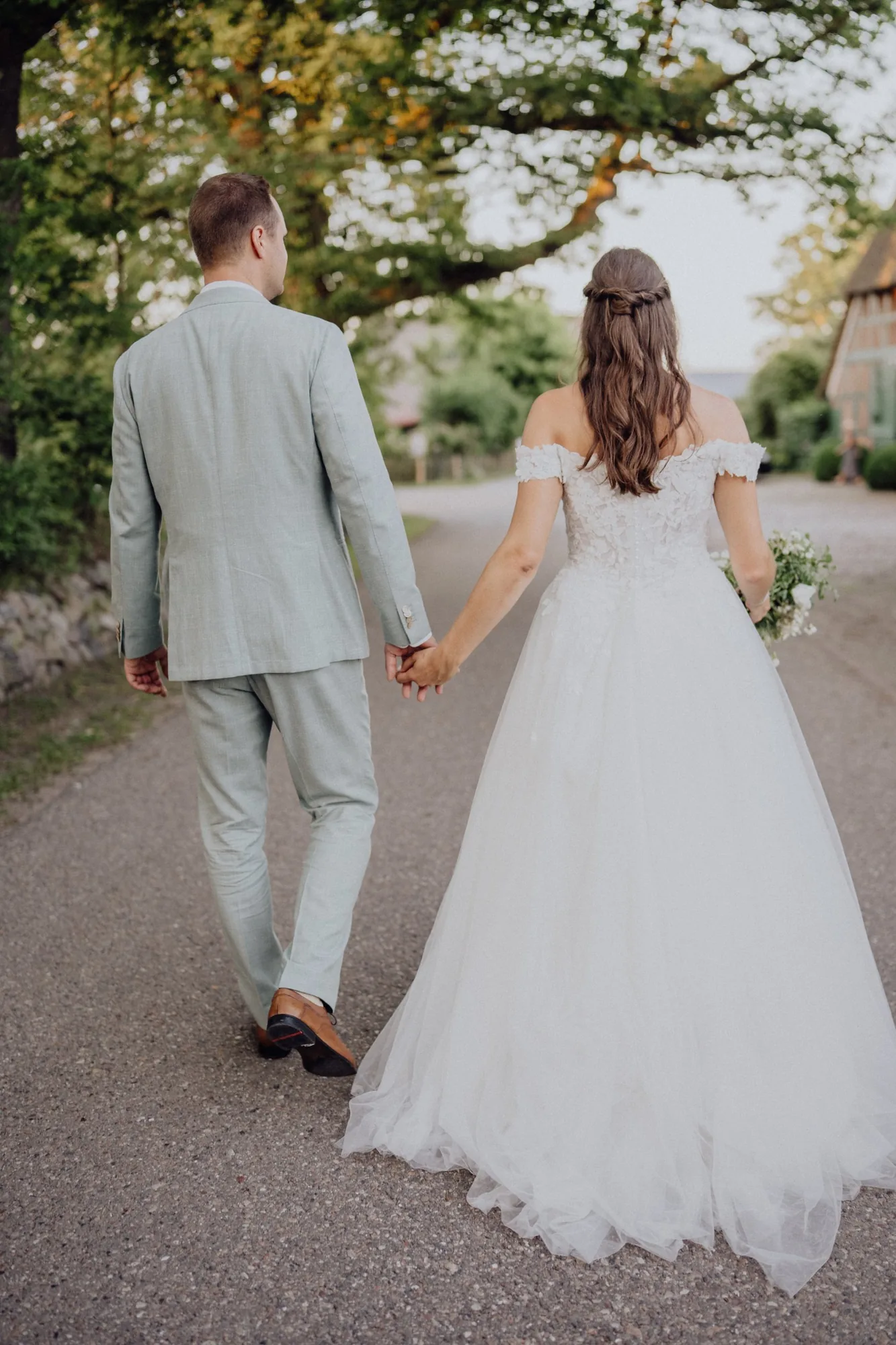 Franzi und Tim gehen Hand in Hand unter einem großen Baum davon – Hochzeit Franzi & Tim, De Ole Schüün, Hüttblek