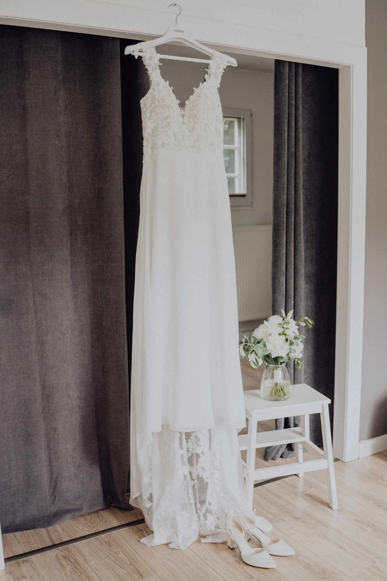 Das Brautkleid hängt mit Schuhen und Brautstrauß bereit – Hochzeit Maria & Jannik, Gut Pronstorf