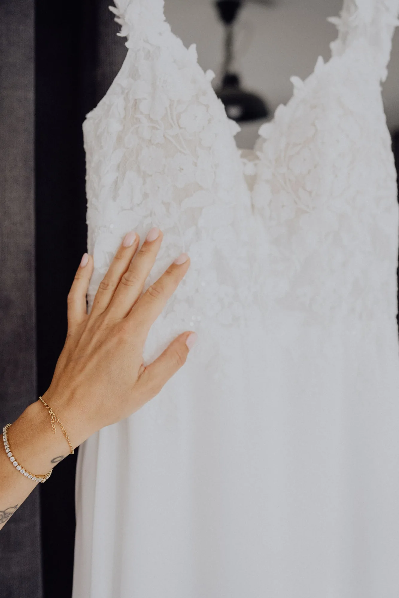 Marias Hand streicht über die Spitze ihres Brautkleids – Hochzeit Maria & Jannik, Gut Pronstorf