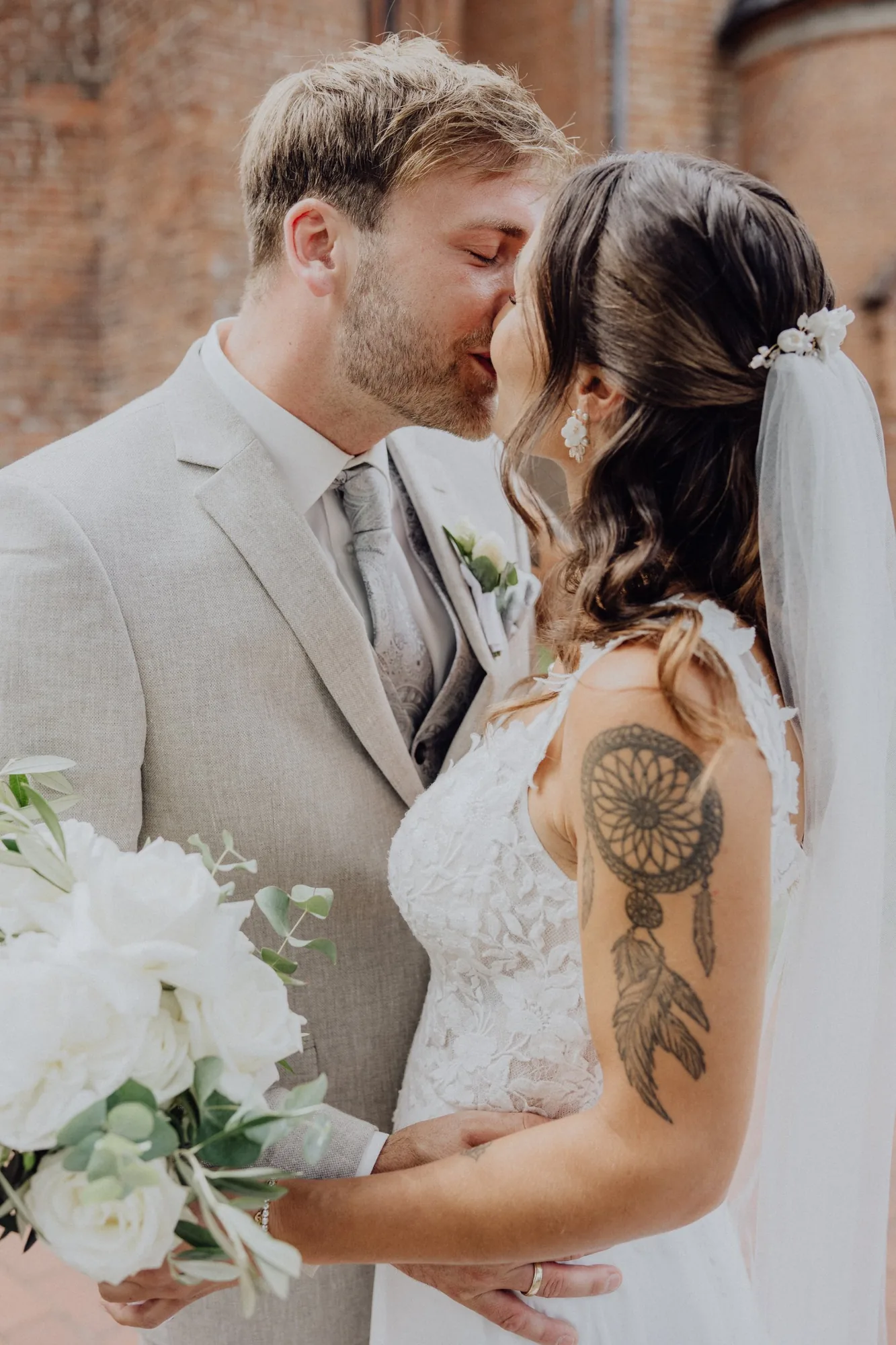 Maria und Jannik küssen sich vor der Backsteinkirche – Hochzeit Maria & Jannik, Gut Pronstorf