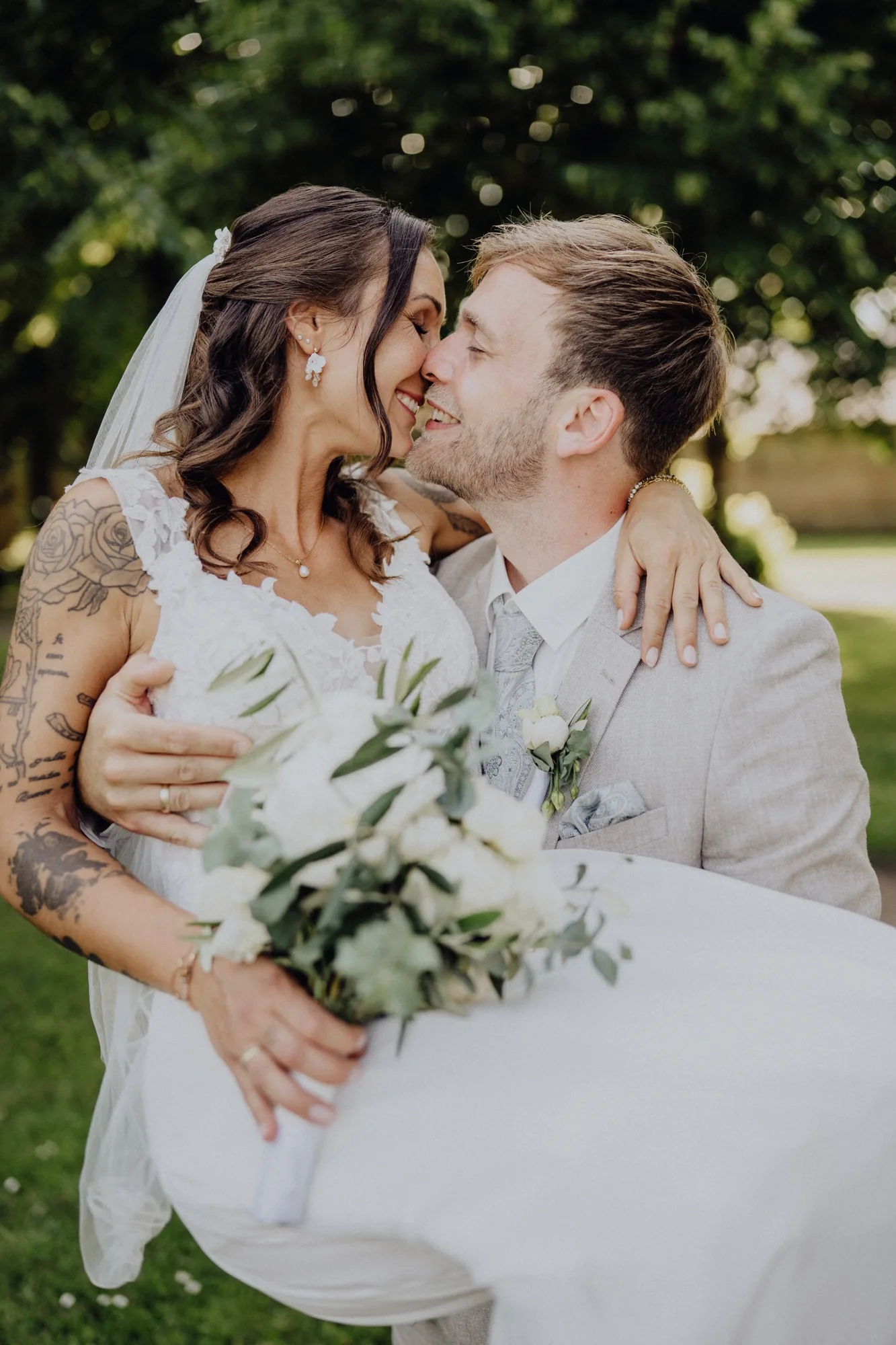 Jannik trägt Maria auf den Armen, beide lachen – Hochzeit Maria & Jannik, Gut Pronstorf