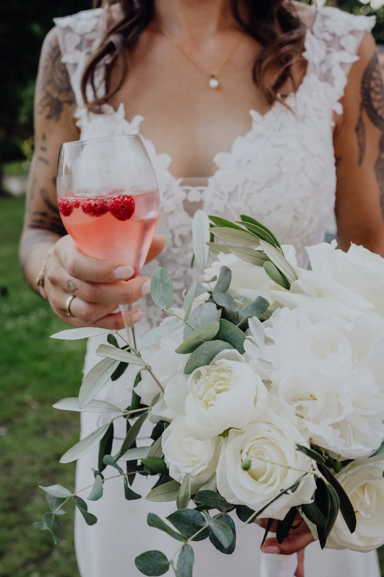 Maria hält einen Himbeer-Aperitif und ihren Brautstrauß – Hochzeit Maria & Jannik, Gut Pronstorf
