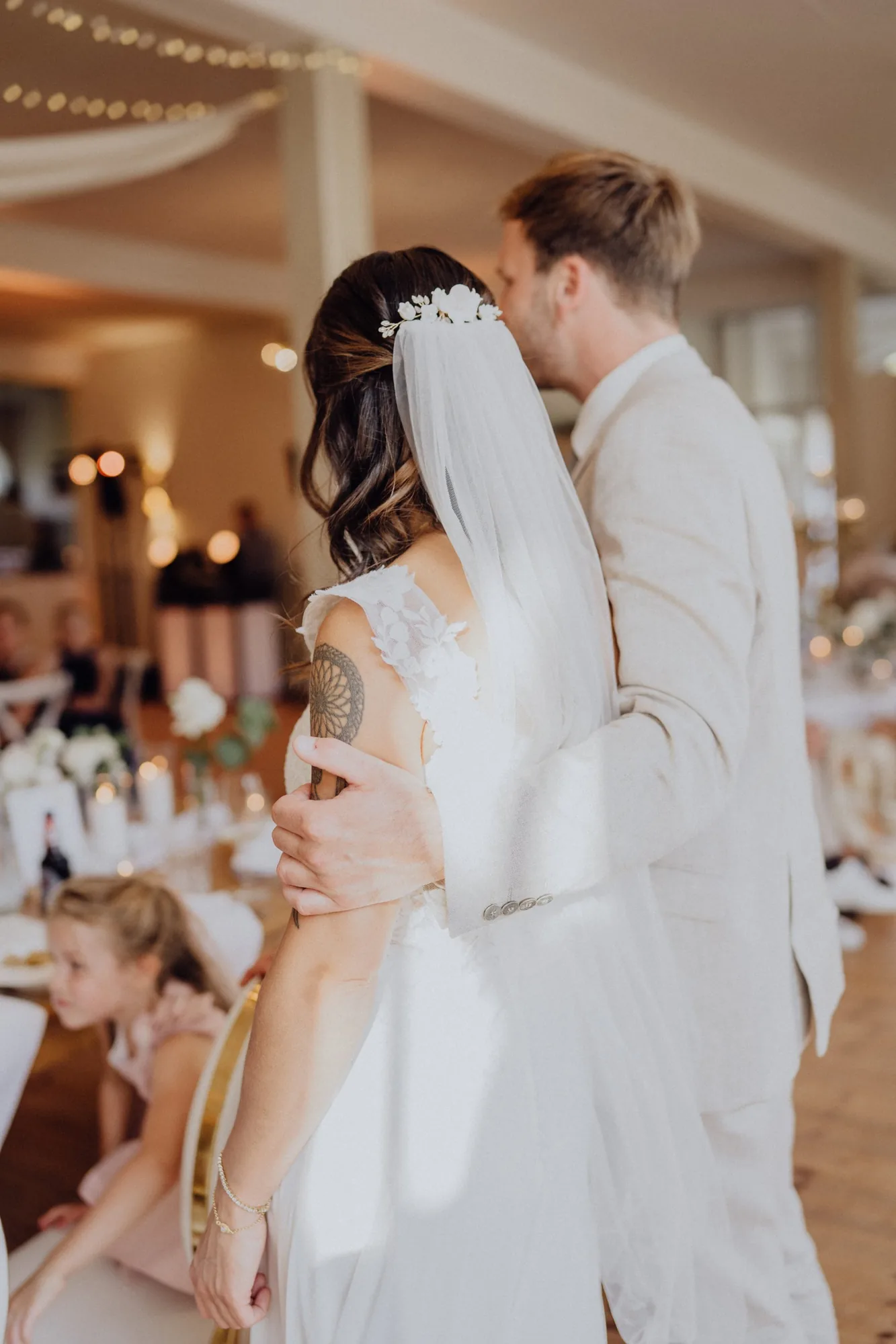 Maria und Jannik eng umschlungen im Saal unter Lichterketten – Hochzeit Maria & Jannik, Gut Pronstorf