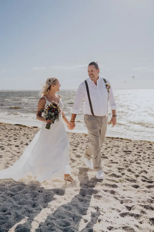 Silja und Florian gehen Hand in Hand am Ostseestrand